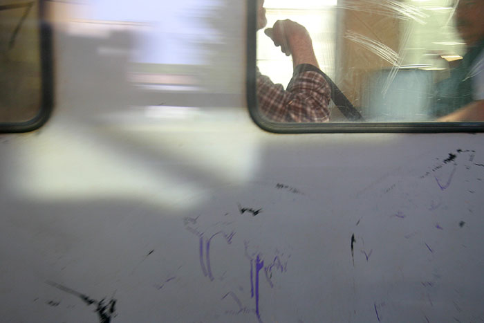 In a speeding instance, a passing train hints at two passengers conversing within, while a colorful reflection paints the side of the car.